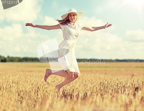 Image of happy young woman jumping on cereal field