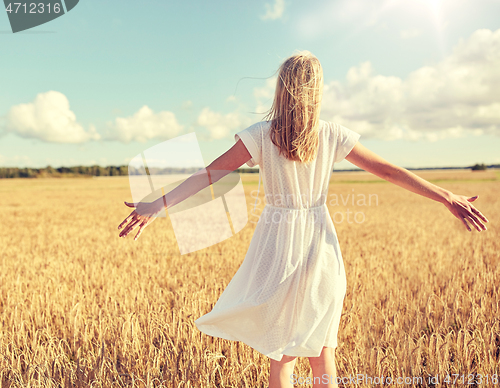 Image of happy young woman in white dress on cereal field