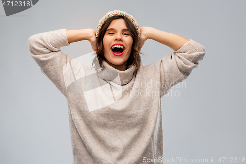 Image of young woman in knitted winter hat and sweater