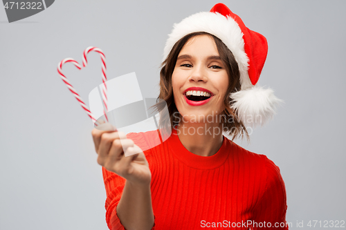 Image of happy young woman in santa hat on christmas