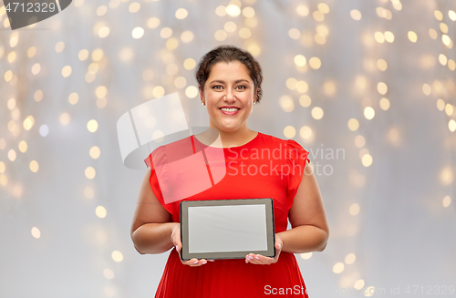 Image of happy woman in red dress holding tablet computer