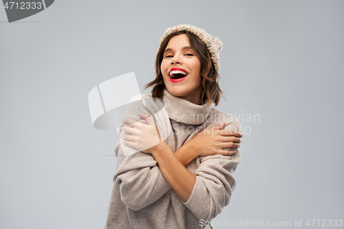 Image of young woman in knitted winter hat and sweater