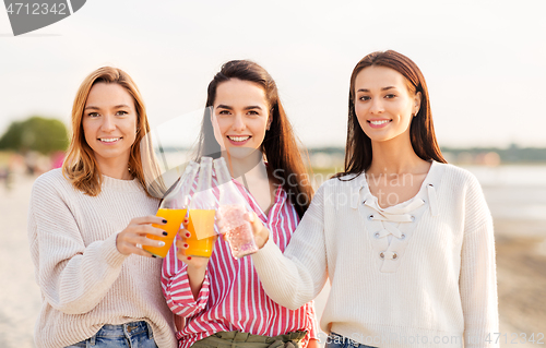 Image of young women toasting non alcoholic drinks on beach