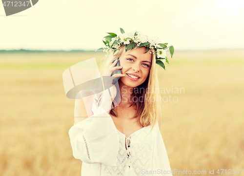 Image of happy young woman calling on smartphone at country