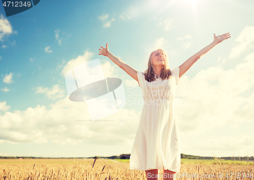 Image of smiling young woman in white dress on cereal field