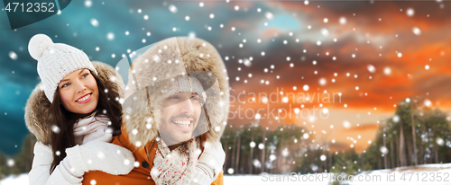 Image of happy couple having fun over winter background