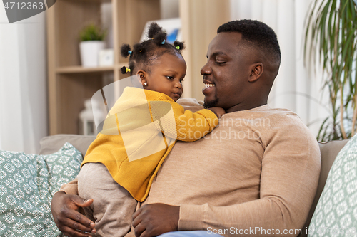 Image of happy african american father with baby at home