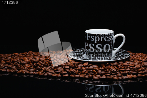 Image of Coffee mug on a pile of coffee beans 