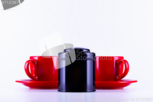 Image of Two red cups of tea and black box on the tea 