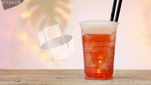 Image of fresh pink soft drink in plastic take away cup 