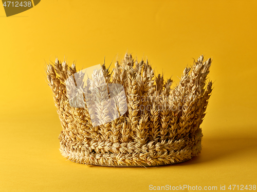 Image of crown made of wheat ears of cereals on a yellow background