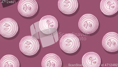 Image of onion slices on purple background