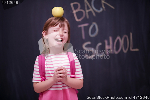 Image of child holding apple on head