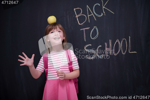 Image of child holding apple on head