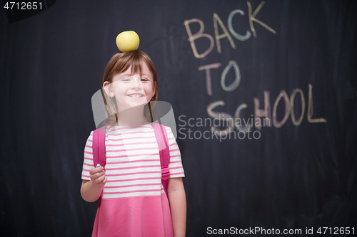 Image of child holding apple on head