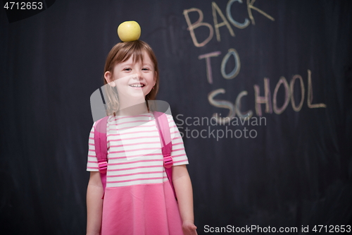 Image of child holding apple on head