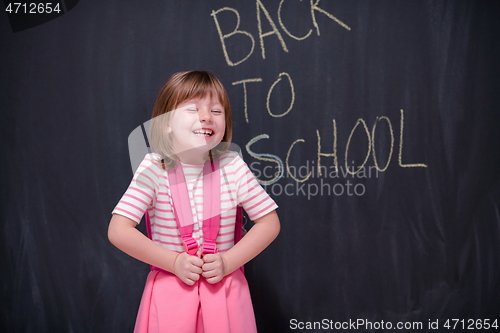 Image of school girl child with backpack writing  chalkboard