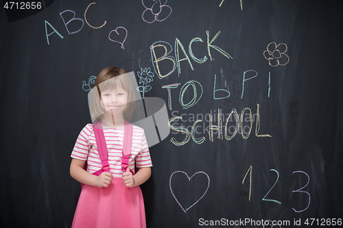 Image of school girl child with backpack writing  chalkboard