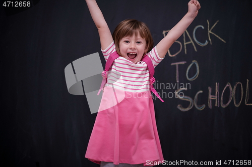 Image of school girl child with backpack writing  chalkboard