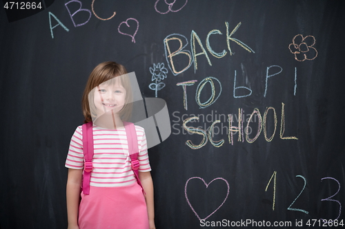 Image of school girl child with backpack writing  chalkboard