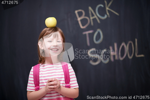 Image of child holding apple on head