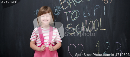 Image of school girl child with backpack writing  chalkboard