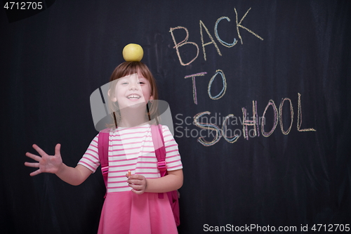 Image of child holding apple on head