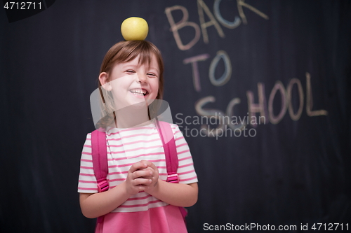 Image of child holding apple on head