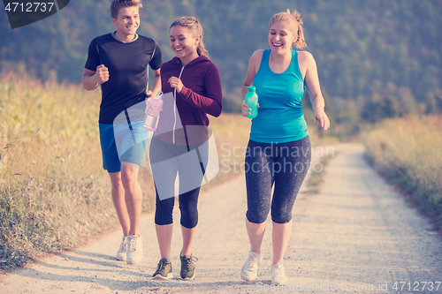 Image of young people jogging on country road