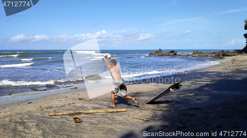 Image of Surfer man stands on sandy beach