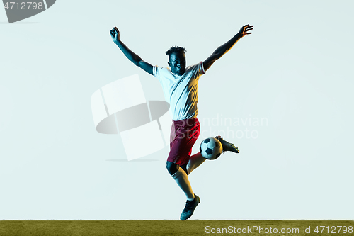 Image of Male soccer player kicking ball isolated on white background