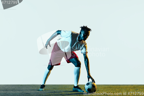 Image of Male soccer player kicking ball isolated on white background