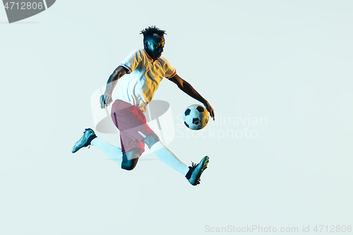 Image of Male soccer player kicking ball isolated on white background