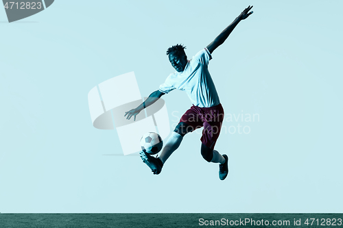 Image of Male soccer player kicking ball isolated on white background