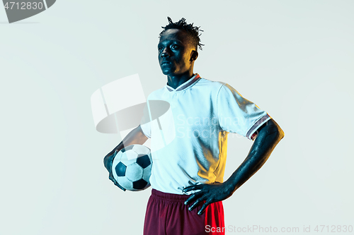 Image of Male soccer player standing with the ball isolated on white background