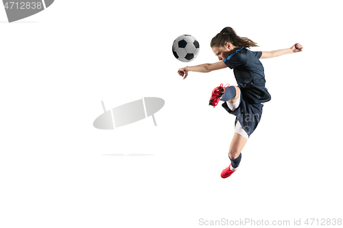 Image of Female soccer player kicking ball isolated over white background