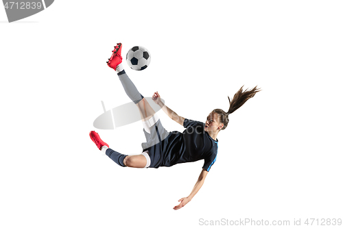 Image of Female soccer player kicking ball isolated over white background