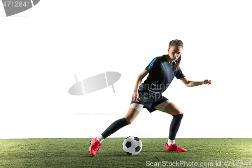 Image of Female soccer player kicking ball isolated over white background