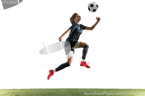 Image of Female soccer player kicking ball isolated over white background