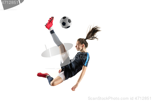 Image of Female soccer player kicking ball isolated over white background