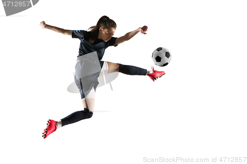 Image of Female soccer player kicking ball isolated over white background