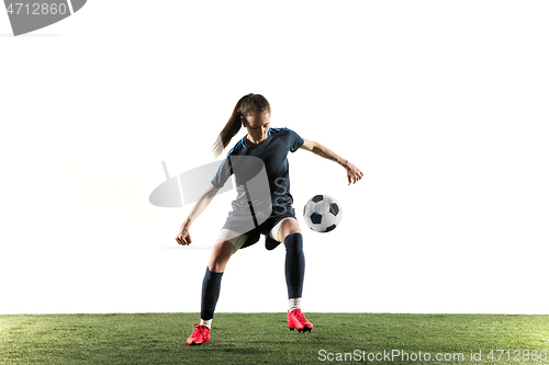 Image of Female soccer player kicking ball isolated over white background