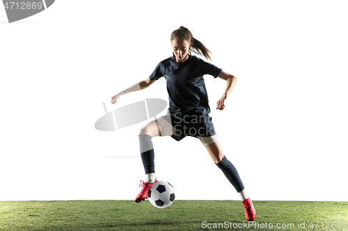 Image of Female soccer player kicking ball isolated over white background