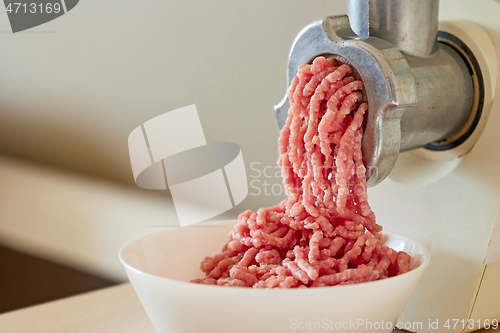 Image of mince the meat with an electric meat mincer