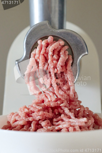 Image of mince the meat with an electric meat mincer
