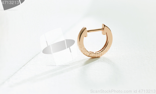 Image of gold earring on a white background 