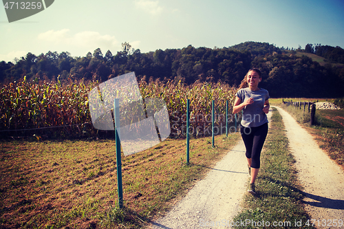 Image of woman jogging along a country road