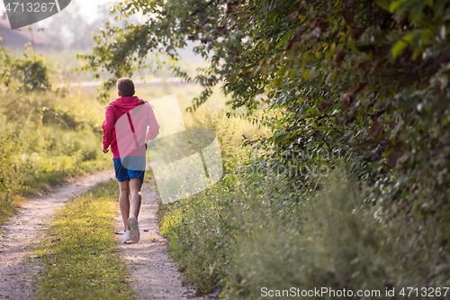 Image of man jogging along a country road