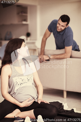 Image of pregnant couple checking a list of things for their unborn baby