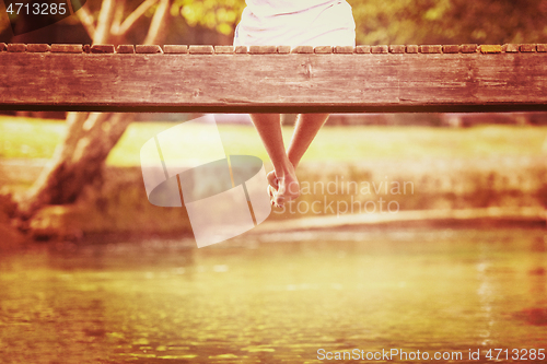 Image of people sitting at wooden bridge